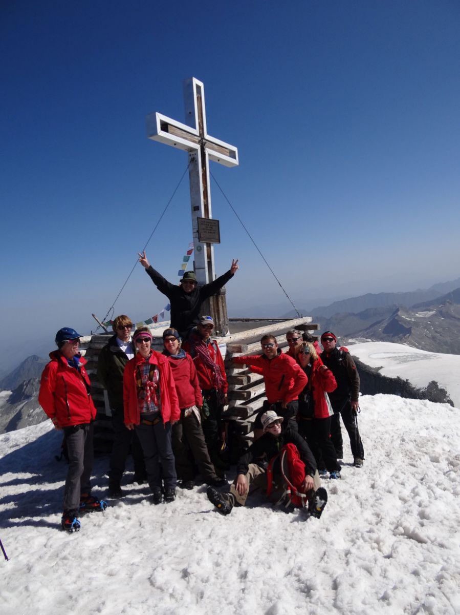Hans-Peter Gassner mit Gästen am Gipfel beim Gipfelkreuz