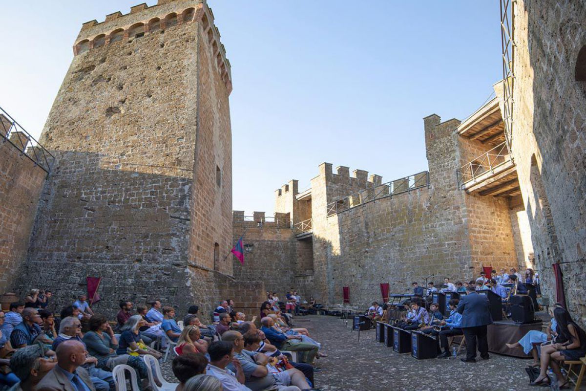 Menschen lauschen in einem alten Castell einem Konzert. 