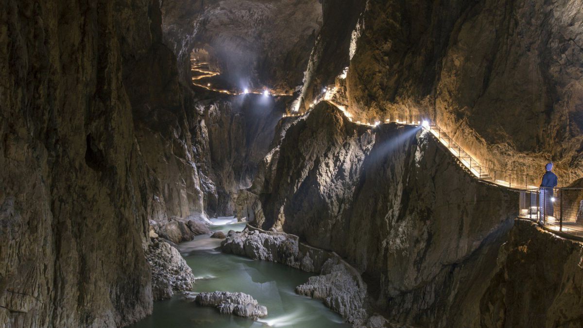 Im Inneren der Höhle, unten der Fluss, an der linken wand ein beleuchteter Steg.